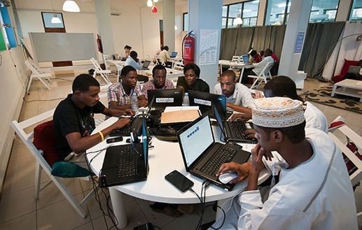 Group of hopeful young Nigerian graduates and job seekers exploring digital economic opportunities on their devices