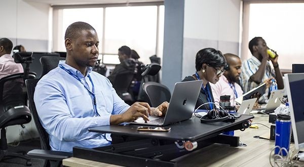 Young Nigerian entrepreneur confidently accessing new digital economic opportunities and pathways on a laptop